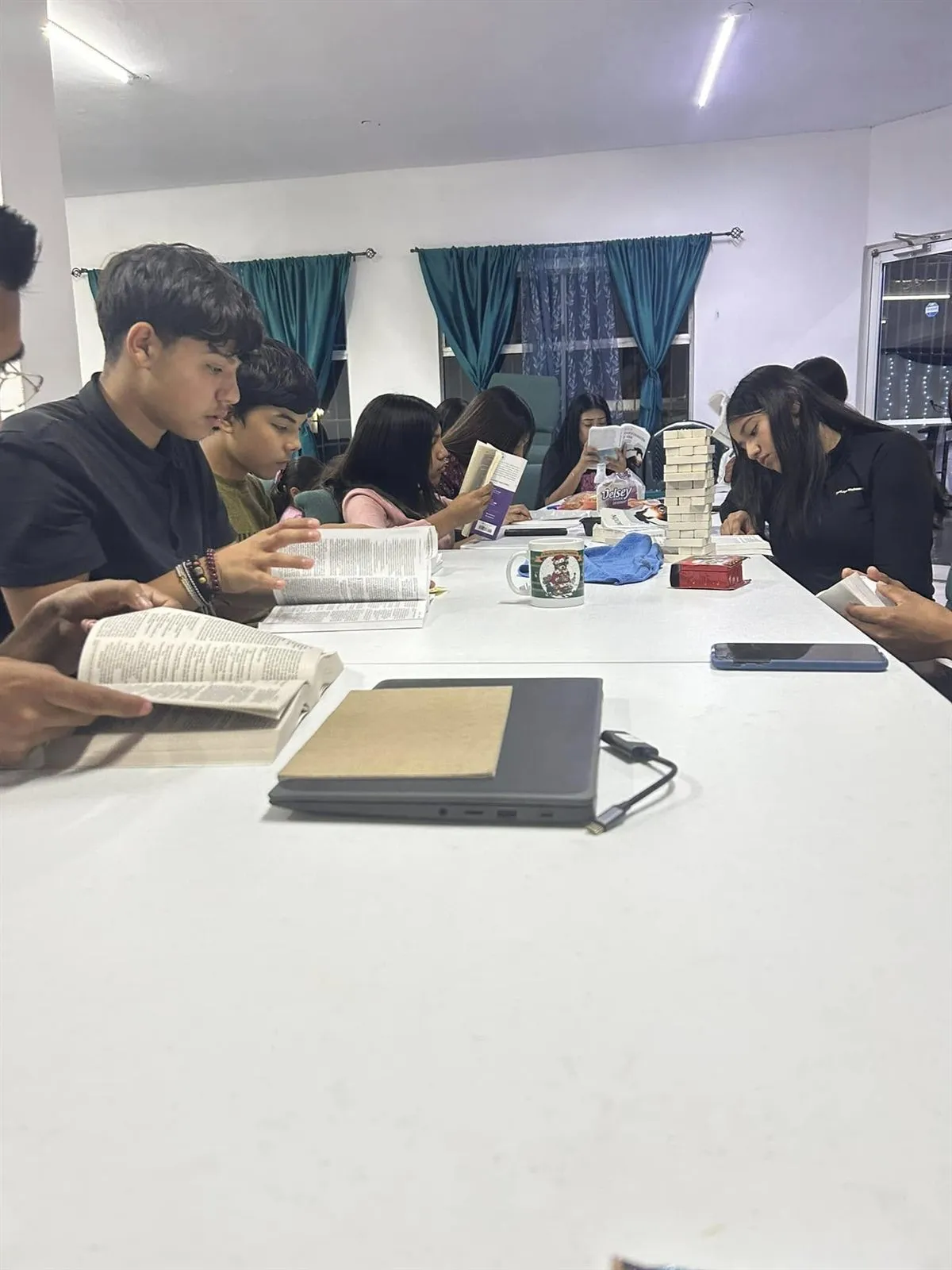 Teenagers studying their Bibles around a table at a youth night at Faith Family Church Rocky Point